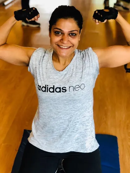 I build strong relationships with my clients. Here is a client showing off her new arm muscles after a tough session. Seeing my clients happy and proud is the best reward.