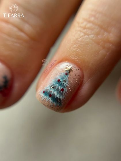 A detailed look at a hand-painted Christmas tree, complete with tiny ornaments and a star on top.