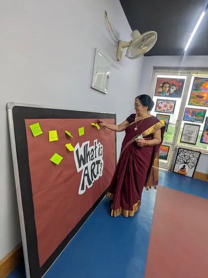A teacher interacts with our "What is Art?" board, a space for students and visitors to share their thoughts. This reflects our philosophy of making art an inclusive and thought-provoking conversation.