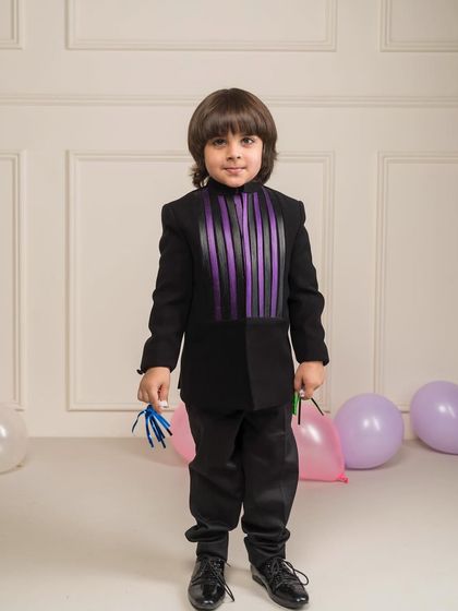 This black bandhgala suit has a unique design element with purple and black ribbons woven into the front panel. It's a contemporary design perfect for a cocktail party or sangeet.