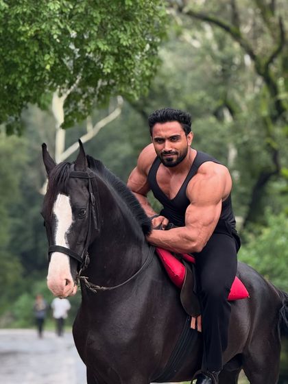 Posing on the horse, showing the bicep peak.