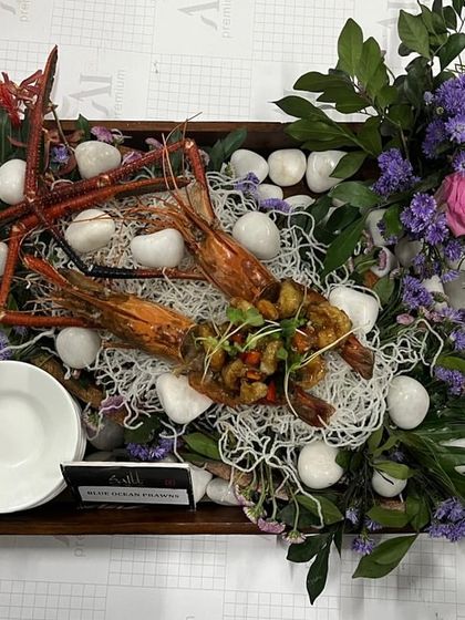 A show-stopping platter of giant prawns, beautifully arranged on a bed of fine noodles and surrounded by fresh flowers. This is how we make a statement with our seafood offerings.