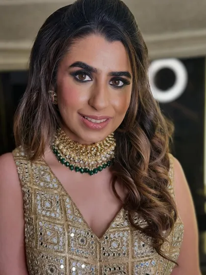 A close-up of the client's hair and makeup. The soft waves are styled with a slight lift at the roots, and the look is paired with a dramatic smokey eye, one of my signature makeup offerings.