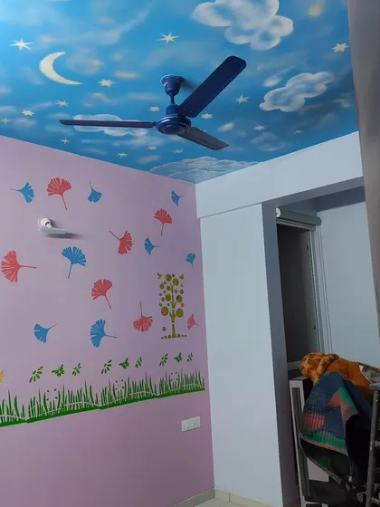 We love making kids' rooms magical. This project features a hand-painted sky ceiling with clouds, a moon, and stars, paired with colorful ginkgo leaf stencils on the walls to create a playful and dreamy atmosphere.