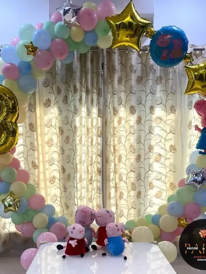 A simple and sweet Peppa Pig theme for a third birthday. This ring decoration is filled with pastel balloons, star-shaped foils, and Peppa Pig characters, creating a perfect photo backdrop for a home celebration.