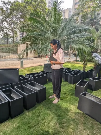 A team member coordinates the layout of the unboxed planters on the lawn. We meticulously plan the arrangement before moving the lightweight FRP containers into their final positions.