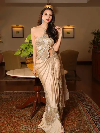 A full-length view of the golden saree-gown. The unique draping and modern silhouette make this a standout piece for any special occasion.