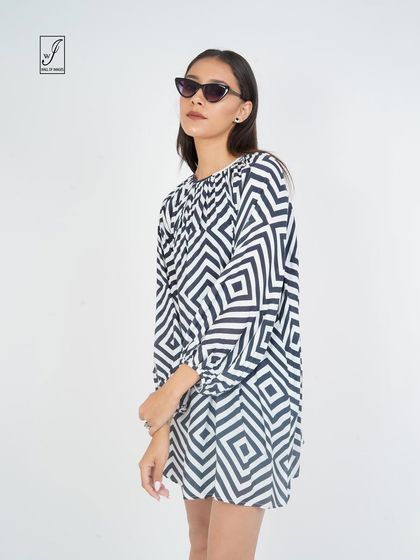 A black and white geometric print dress, shot to emphasize its bold pattern and simple silhouette.