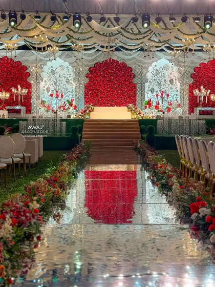 The grand aisle and stage at dusk, with the mirrored path reflecting the warm lights of the opulent red and white decor.