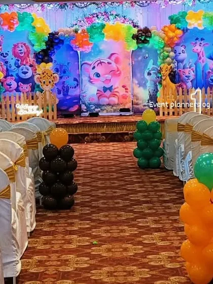 A wide shot of the jungle-themed birthday hall, showing the aisle and stage decor.