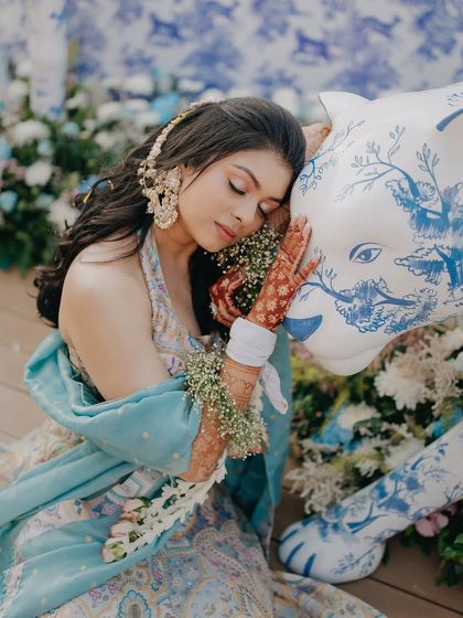 A beautiful, serene portrait of the bride Radhika during her Haldi. Her floral jewelry and the artistic decor element create a stunning and unique image.