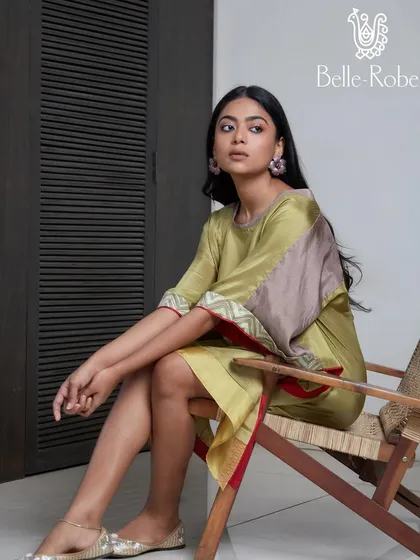 A relaxed and natural makeup look for Belle Robe. The makeup is fresh and minimal, complementing the earthy tones of the green and brown kaftan-style dress.