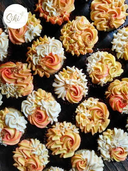 These pineapple-flavored cupcakes are decorated with two-toned buttercream swirls in sunset shades of orange and yellow, with a sprinkle of gold for a tropical feel.