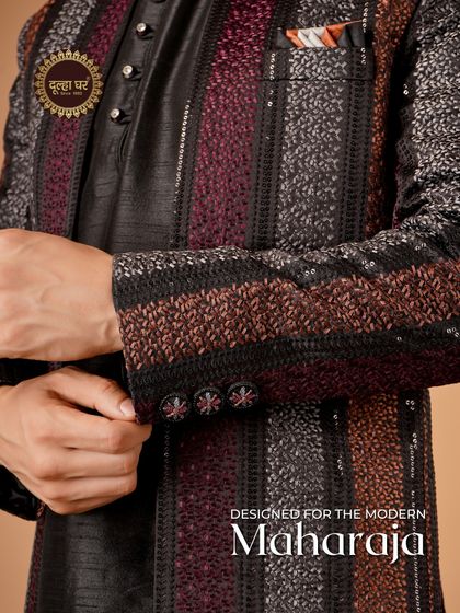 Designed for the modern maharaja. A close-up on the sleeve of a multi-tonal striped Indo-Western jacket, showing the intricate weaving and colors.