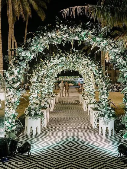 Your guests' first impression matters. We design breathtaking entryways like this grand floral tunnel, creating an immersive experience from the moment they arrive and setting the tone for a spectacular wedding reception.