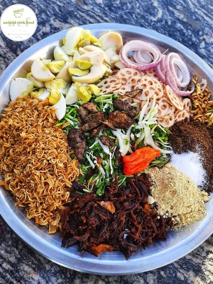 All the fresh ingredients ready to be mixed into a delicious Manipuri singju. We use boiled eggs, lotus stem, fried noodles, and smoked fish.