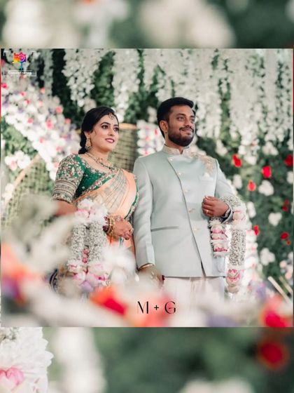 A candid shot of the couple during their ceremony, framed by flowers. This captures a natural, happy moment against a beautifully decorated backdrop.