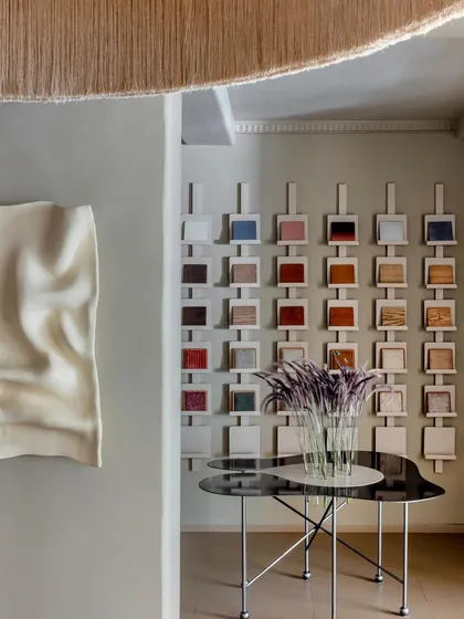 Detail is paramount in our work, as seen in this curated corner of a retail showroom. A sculptural wall art piece and a display of material samples are thoughtfully arranged, demonstrating how we integrate art, texture, and product into a cohesive and engaging brand story.