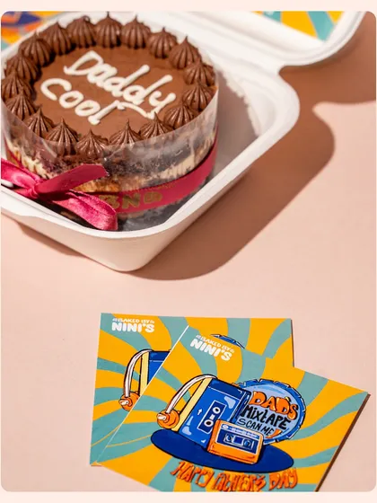 A close-up of a Father's Day cake, paired with its quirky, retro-themed branding cards. This shot highlights the creative details that make a product special.