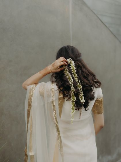 A back view of the bride's Haldi look, showcasing her beautiful gajra hairstyle.
