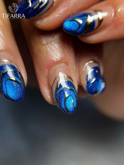 A macro shot of the deep blue cat-eye nail with shimmering silver chrome accents, evoking the movement of ocean waves.