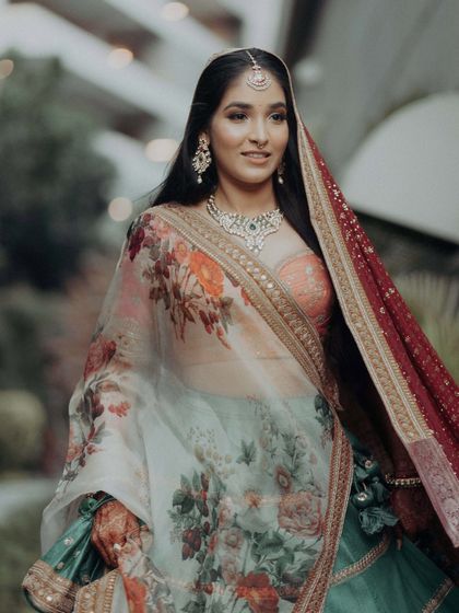 A close-up of the bride, her smile lighting up the frame. This shot captures her happiness and the beautiful floral details of her Sangeet dupatta.