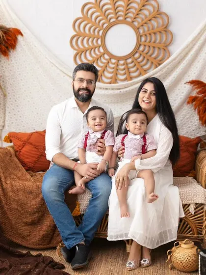 The complete family portrait with twin boys. This image beautifully captures the joy and love of this family of four in a warm and inviting setting.