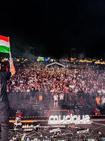 Like Mike holds the Indian flag high, looking out over a massive crowd of fans at their Bengaluru show.