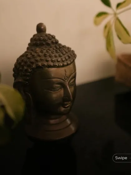 A close-up of a bronze Buddha head, a decorative piece that adds a sense of tranquility and spiritual calm to the interior space.