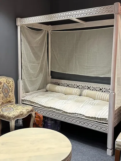 A beautiful four-poster daybed with intricate carving, showcasing our expertise in creating custom, statement furniture pieces.
