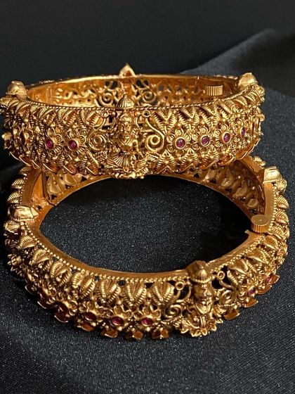 Another pair of stunning rental bangles with intricate floral and deity carvings. The kemp stone accents add a touch of colour.