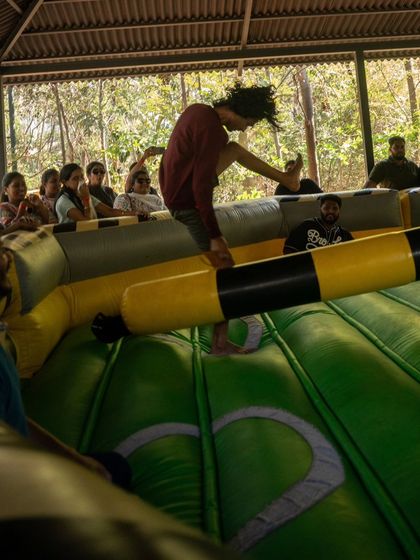 A participant leaps over the swinging arm in the Meltdown game, showing off some impressive agility.