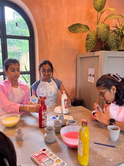 The fun doesn't stop at making. After their pieces are formed, the kids get to paint them. These girls are enjoying the painting part of their pottery playdate, adding color to their new vases.