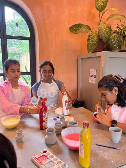 The fun doesn't stop at making. After their pieces are formed, the kids get to paint them. These girls are enjoying the painting part of their pottery playdate, adding color to their new vases.