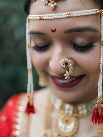 A close-up focusing on the traditional Maharashtrian bridal jewelry, the 'mundavalya' and 'nath', which are essential parts of the look.