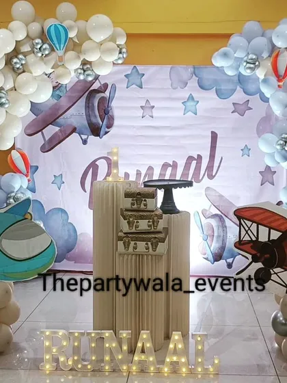 An airplane theme party with cute plane cutouts and a "cloud" of white balloons. The light-up name sign adds a personalized touch to this adventurous theme.