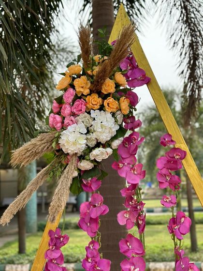 A beautiful floral bunch with pink orchids, roses, and pampas grass, part of the modern and stylish Haldi decor.