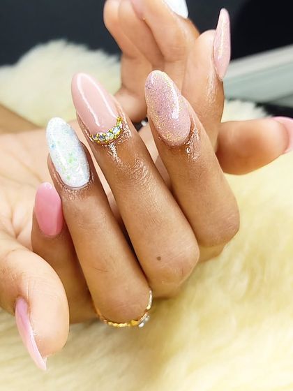 A soft and pretty set combining pink gel polish, glitter accent nails, and a delicate rhinestone cuticle design.