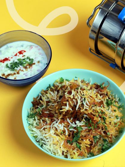 Our special Chicken Biryani served with cooling raita. It's a weekend favorite and a party classic, slow-cooked with fragrant spices to capture that authentic home-style flavor.