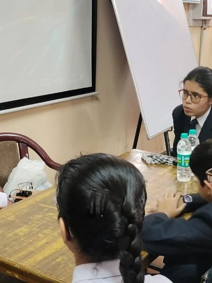 An instructor provides focused guidance to a small group of students, answering their questions and helping them troubleshoot their project.