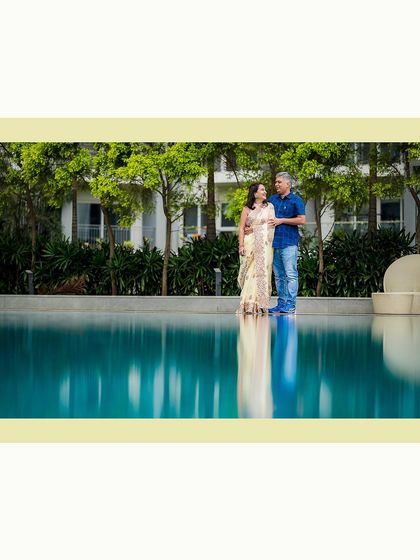 A stunning portrait of a couple by a reflecting pool, creating a beautiful, serene image for their anniversary photoshoot.