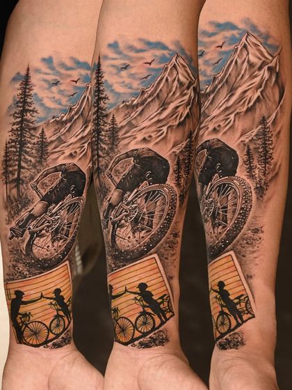 A stunning realism piece capturing a father-son bond through cycling. This tattoo blends a dynamic action shot with a tender silhouette, telling a story of shared passion.