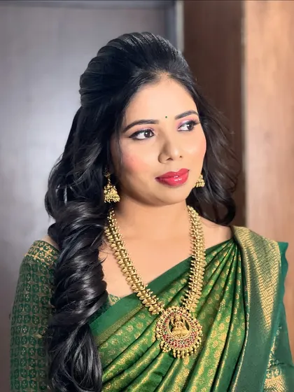 A beautiful look for a ring ceremony, featuring a green silk saree and soft, glowing makeup.