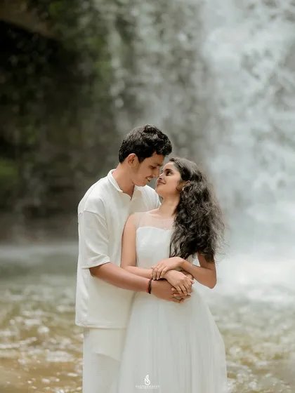 A close-up portrait in front of the waterfall, focusing on the couple's intimate connection amidst the spray and sound of the water.