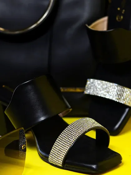 A styled shot of the Dressberry heels with a matching black handbag, creating a coordinated accessory look for an e-commerce brand.