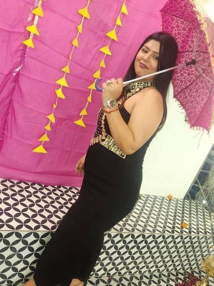 A playful pose in the black jumpsuit. The umbrella prop adds a fun element to the festive look.