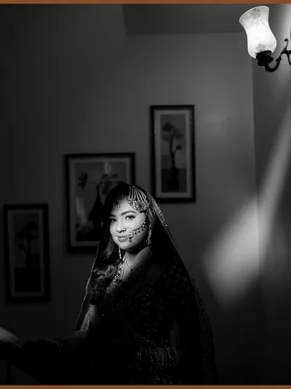A stunning black and white portrait of the Nikah bride. The dramatic lighting highlights her beautiful features and traditional jewelry.