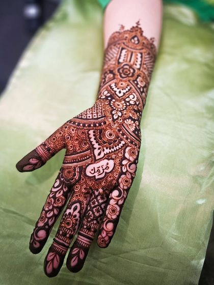 A special anniversary henna with the name "Maryam" beautifully written in Arabic script on the palm.