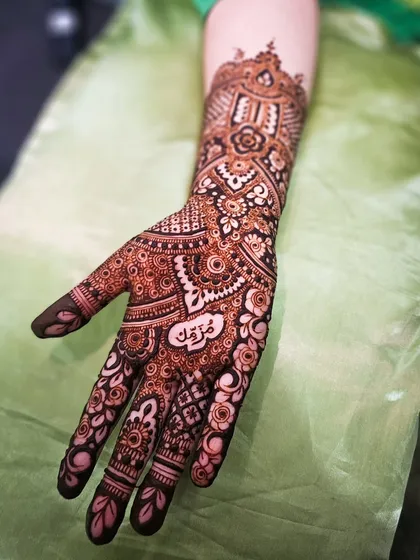 A special anniversary henna with the name "Maryam" beautifully written in Arabic script on the palm.