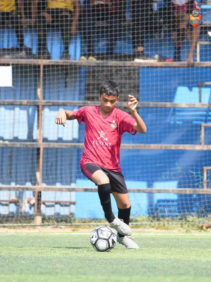A young player showing great ball control under pressure during a crucial Leno Premier League match.